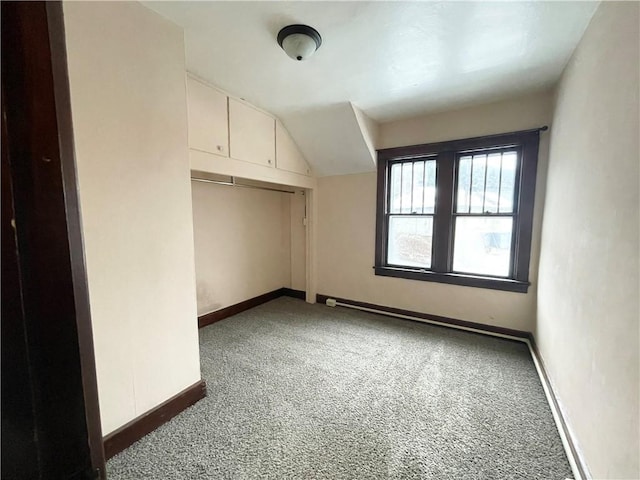 bonus room featuring dark colored carpet and vaulted ceiling