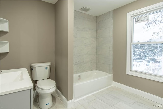 full bathroom featuring vanity, tiled shower / bath combo, and toilet