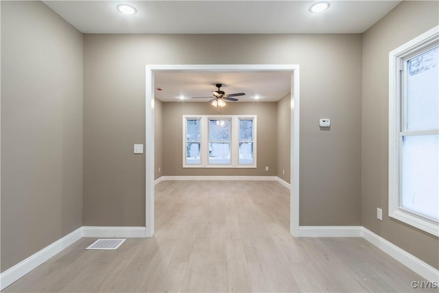 unfurnished room with plenty of natural light, ceiling fan, and light hardwood / wood-style flooring