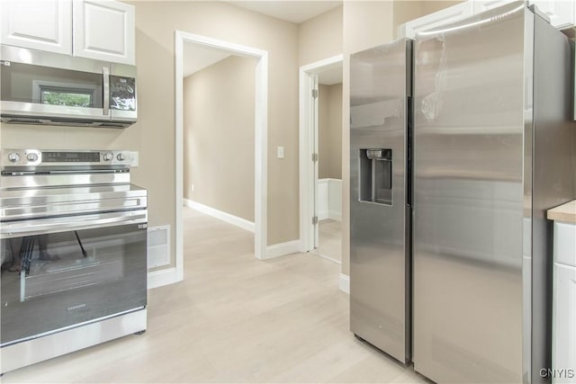 223 S Washington St, Wilna, NY 13619 - kitchen with stainless steel appliances, white cabinetry, light wood-style floors, and light countertops