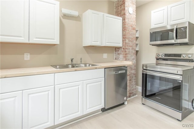223 S Washington St, Wilna, NY 13619 - kitchen with stainless steel appliances, white cabinets, light countertops, and light wood-style floors