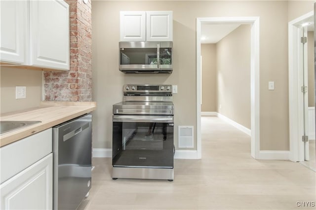 223 S Washington St, Wilna, NY 13619 - kitchen with stainless steel appliances, white cabinets, light wood-style floors, and light countertops