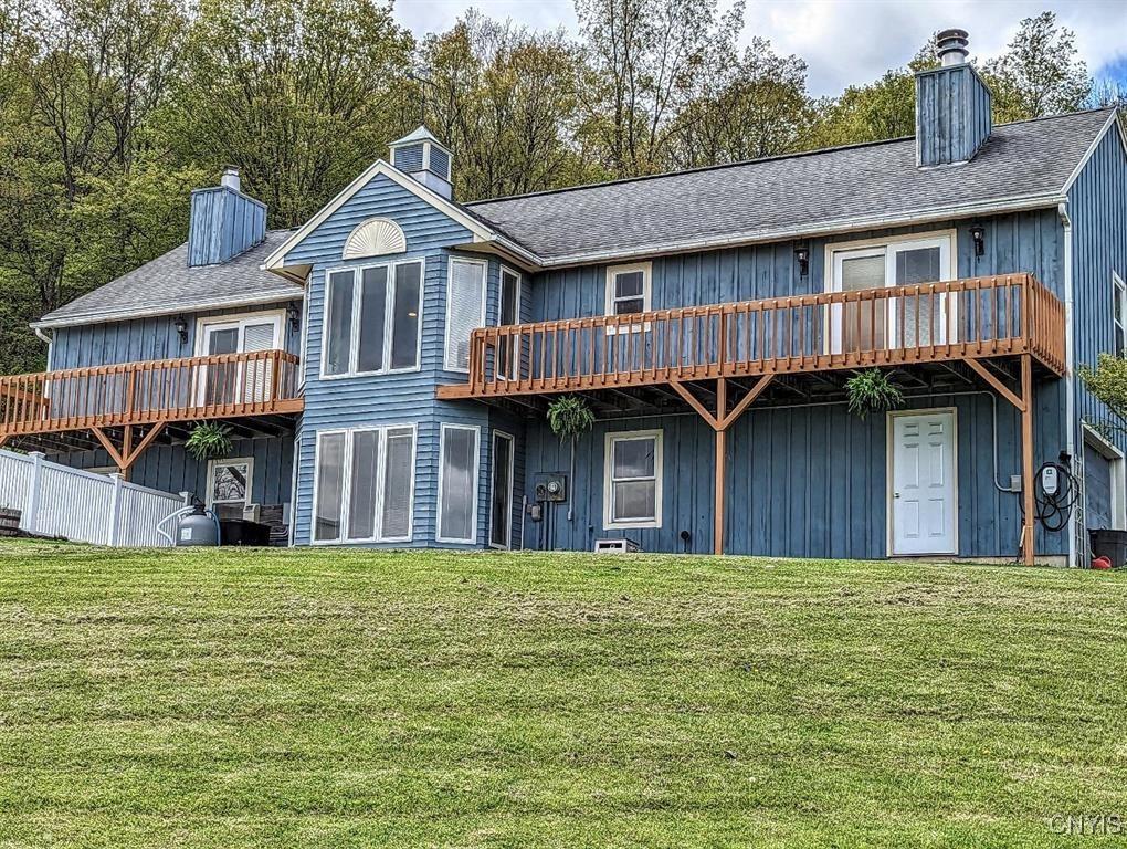 rear view of property with a yard and a wooden deck