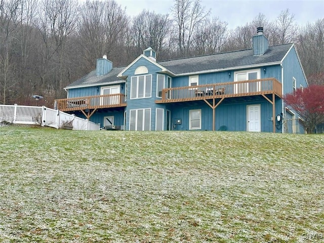 rear view of house featuring a yard and a deck