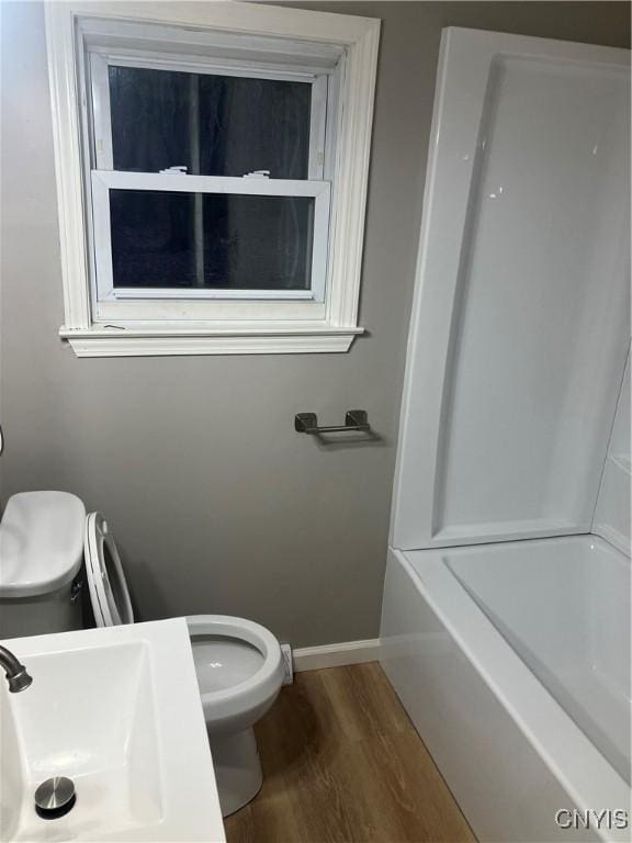 full bathroom featuring wood-type flooring, toilet, shower / bathtub combination, and sink