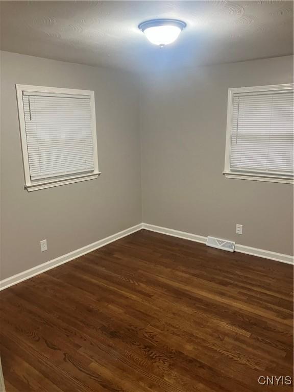 unfurnished room featuring dark hardwood / wood-style flooring