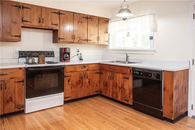 kitchen featuring sink, dishwasher, white electric range oven, decorative light fixtures, and light wood-type flooring