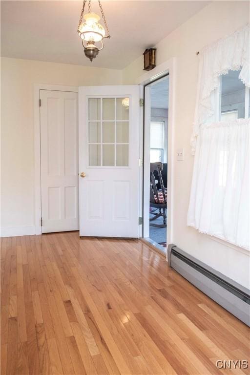 interior space featuring wood-type flooring and a baseboard radiator