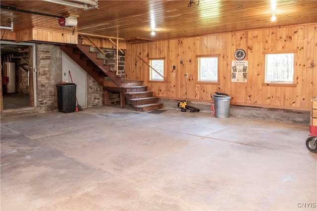 basement featuring wooden walls, gas water heater, and wooden ceiling