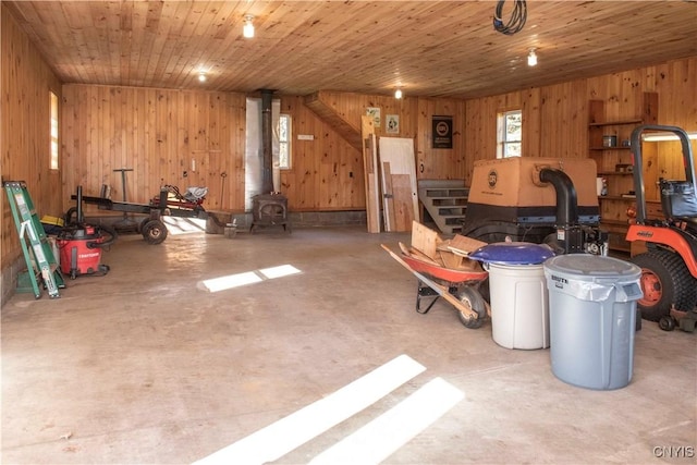 garage with wood walls, wood ceiling, and a wood stove