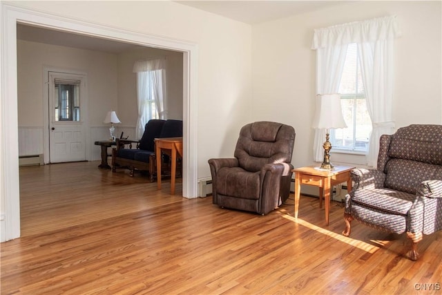 living area with a baseboard radiator and light hardwood / wood-style floors