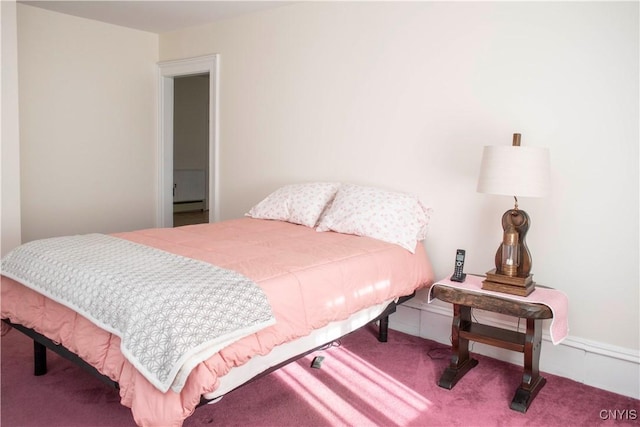 carpeted bedroom with a baseboard heating unit