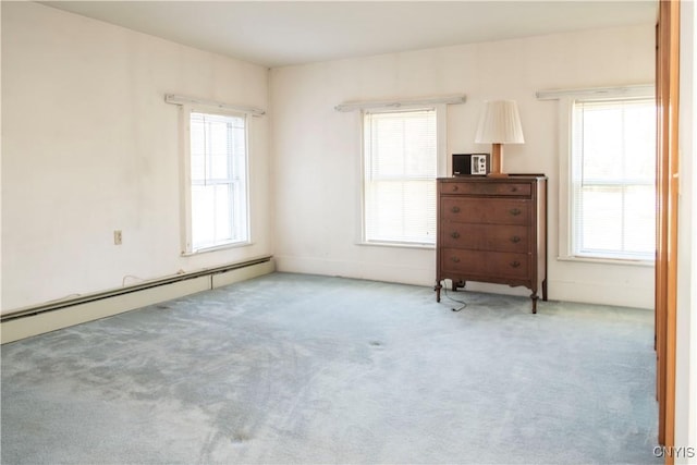 carpeted spare room with a baseboard radiator and plenty of natural light