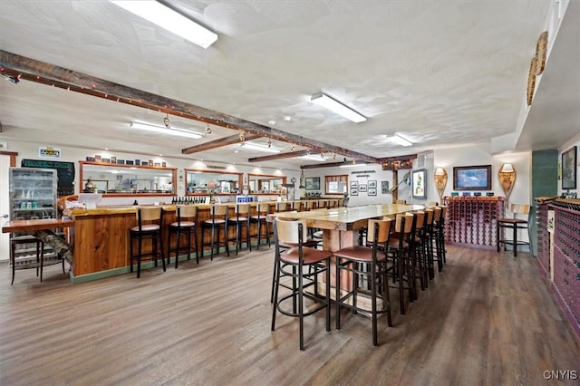 dining space featuring hardwood / wood-style floors and bar