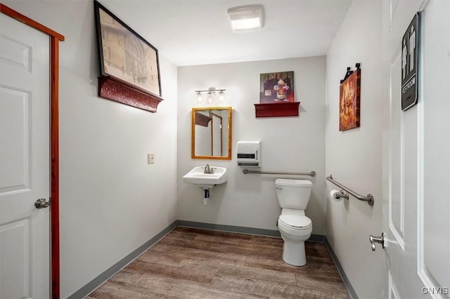 bathroom featuring toilet, wood-type flooring, and sink