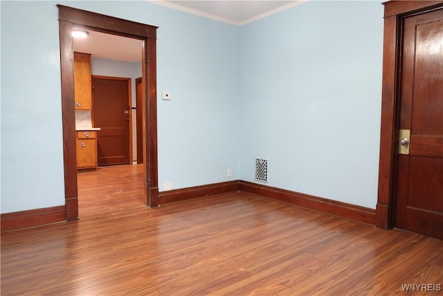 unfurnished room featuring light hardwood / wood-style floors and ornamental molding