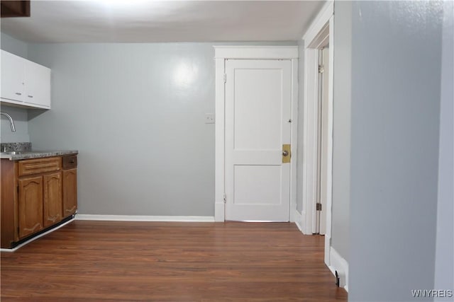 kitchen with sink, white cabinetry, and dark wood-type flooring