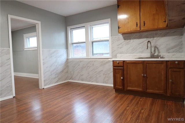 kitchen featuring dark hardwood / wood-style floors, tile walls, and sink