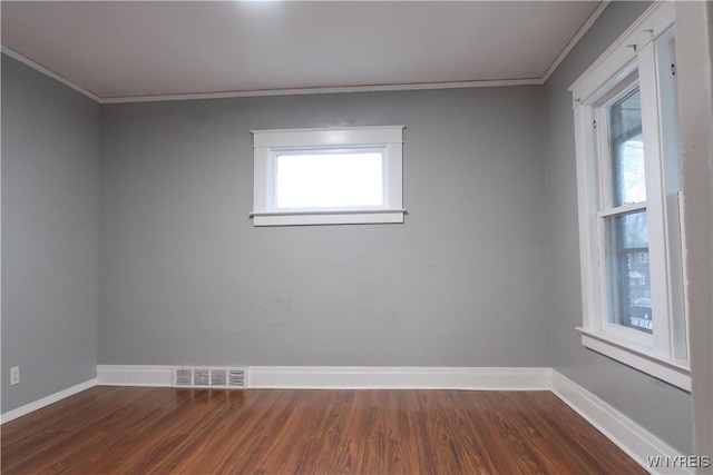 spare room featuring crown molding and dark hardwood / wood-style floors