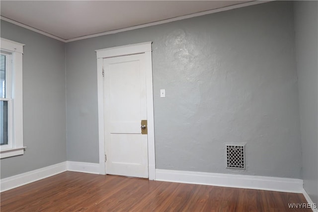 spare room with crown molding and hardwood / wood-style flooring