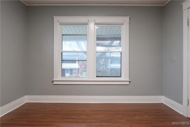 spare room with dark hardwood / wood-style flooring and ornamental molding