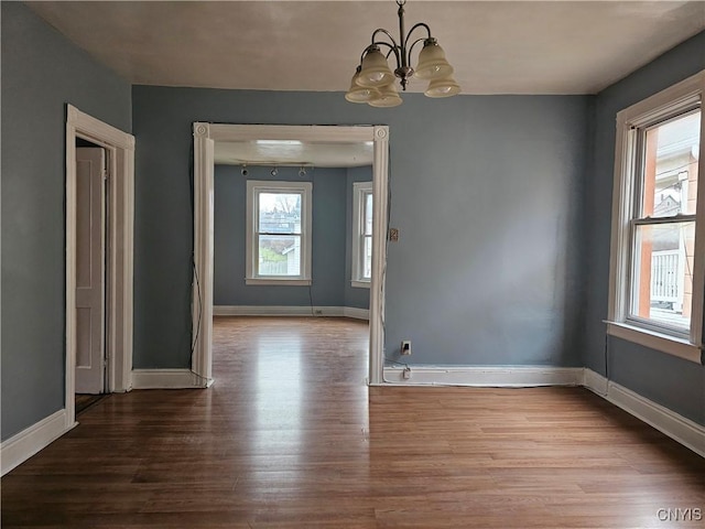 unfurnished dining area with a notable chandelier and wood-type flooring