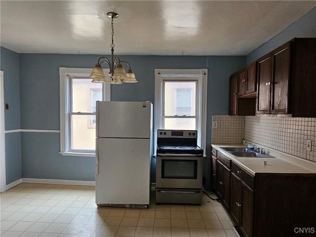 kitchen with plenty of natural light, white refrigerator, stainless steel electric range oven, and sink