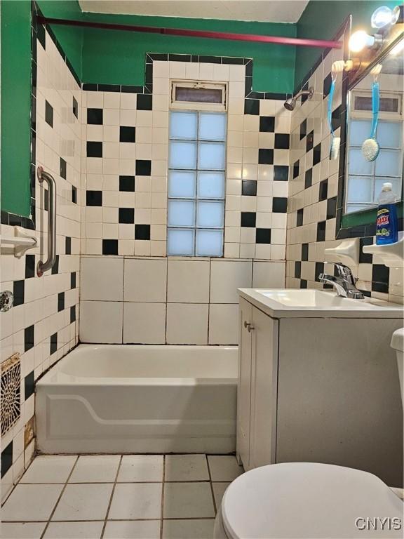 full bathroom featuring vanity, bathing tub / shower combination, tile walls, tile patterned flooring, and toilet