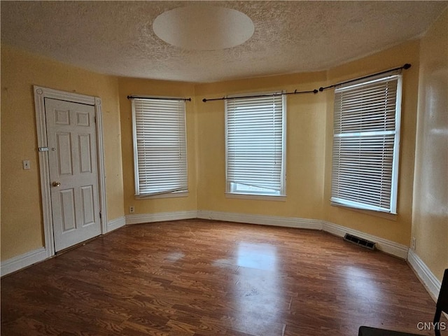 unfurnished room featuring hardwood / wood-style floors and a textured ceiling