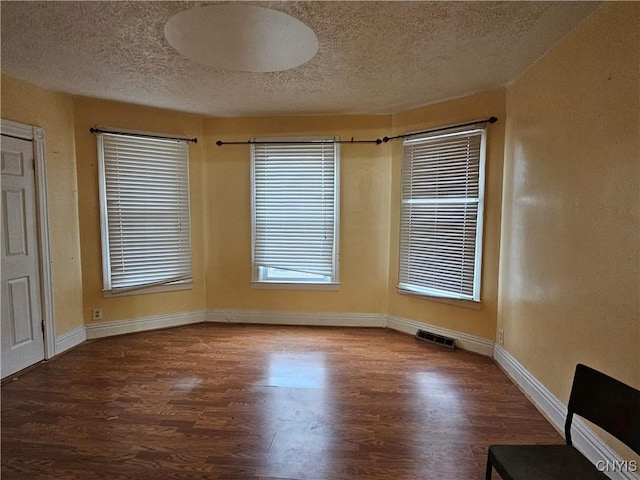 empty room featuring hardwood / wood-style floors and a textured ceiling