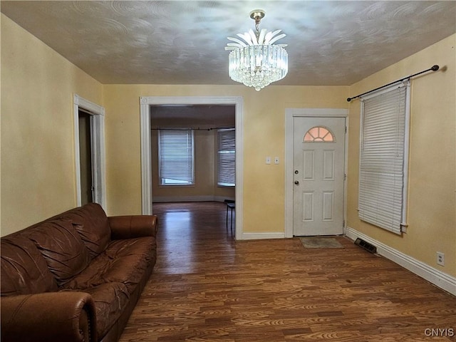 entryway with a notable chandelier and dark hardwood / wood-style flooring