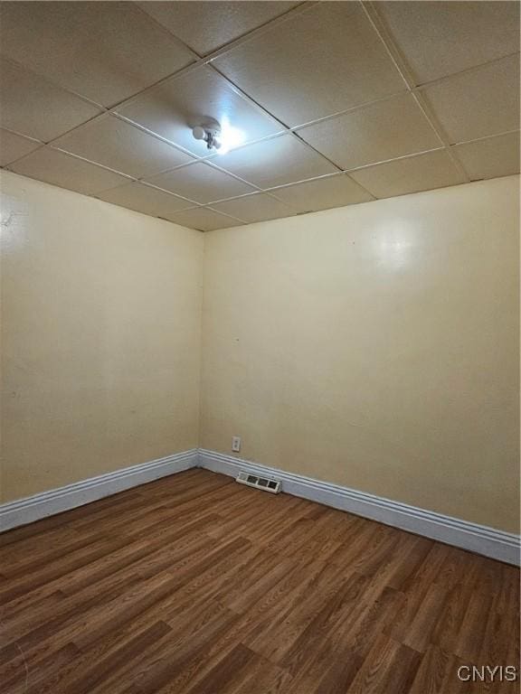 spare room featuring a paneled ceiling and hardwood / wood-style flooring