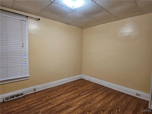 empty room featuring hardwood / wood-style floors and a drop ceiling