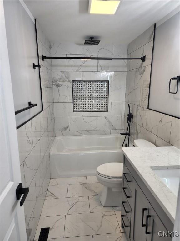 full bathroom featuring vanity, toilet, tile walls, and tiled shower / bath