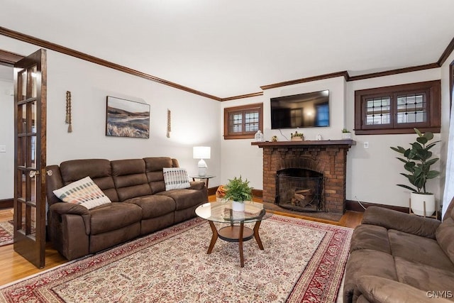 living room with hardwood / wood-style flooring, crown molding, and a fireplace