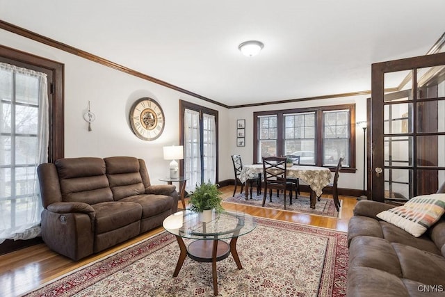 living room featuring hardwood / wood-style flooring, plenty of natural light, and crown molding