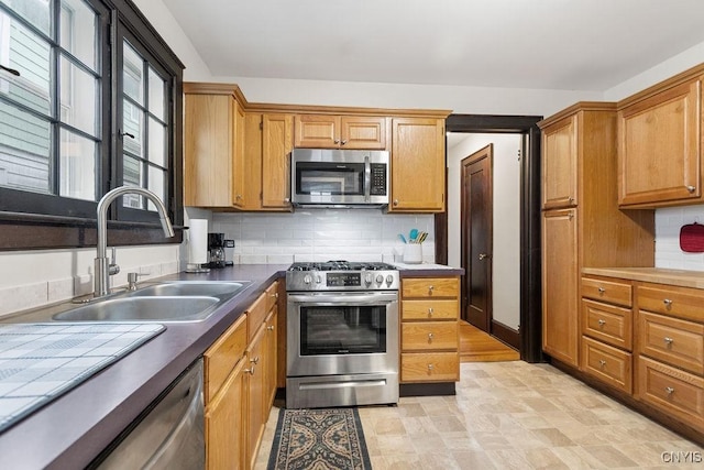 kitchen featuring backsplash, sink, and appliances with stainless steel finishes