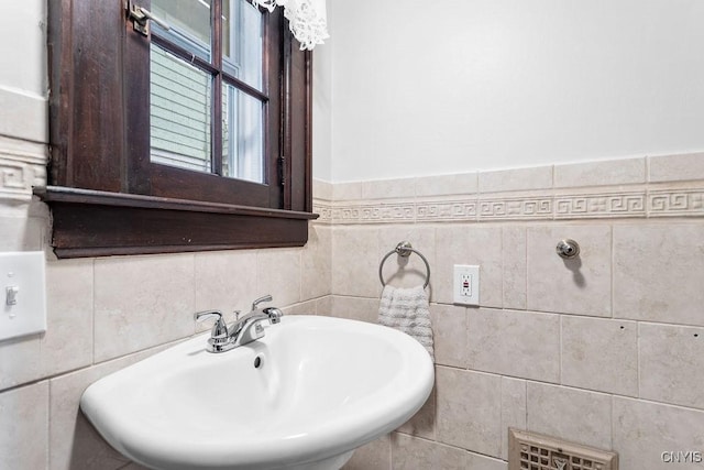 bathroom with tile walls and sink