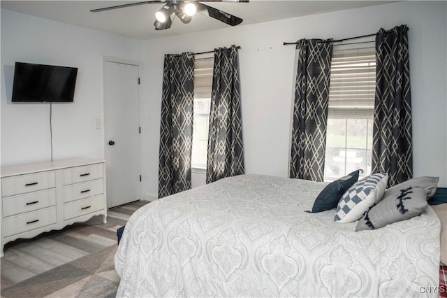 bedroom with light hardwood / wood-style floors and ceiling fan