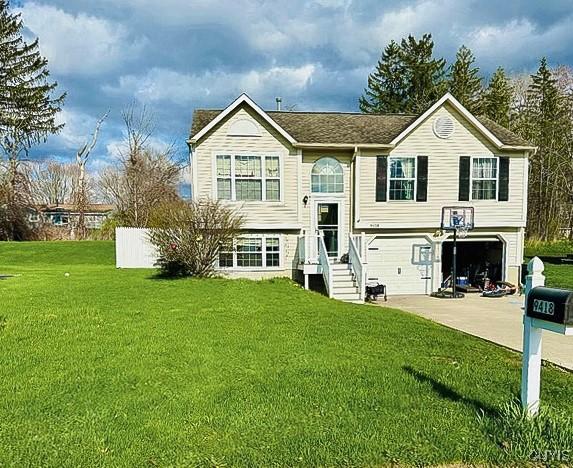 split foyer home featuring a front lawn and a garage