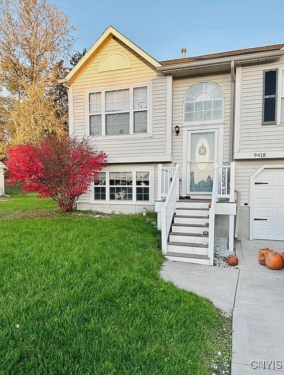 raised ranch with a front yard and a garage