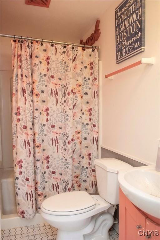 bathroom featuring vanity, curtained shower, and toilet