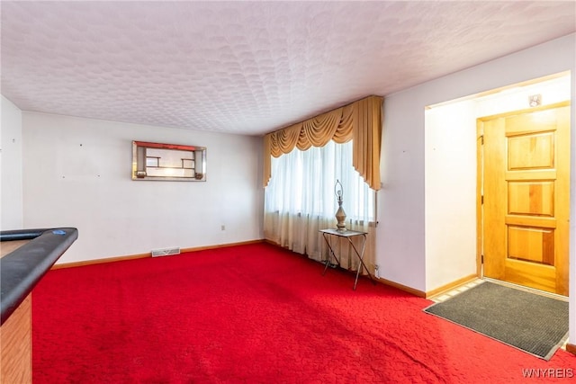 misc room with carpet floors and a textured ceiling