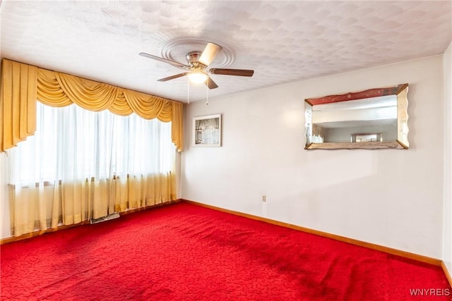 carpeted empty room featuring ceiling fan and a textured ceiling