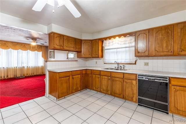 kitchen with dishwasher, sink, ceiling fan, light tile patterned floors, and tasteful backsplash