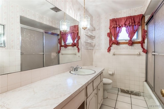 full bathroom with combined bath / shower with glass door, vanity, tile patterned floors, and tile walls