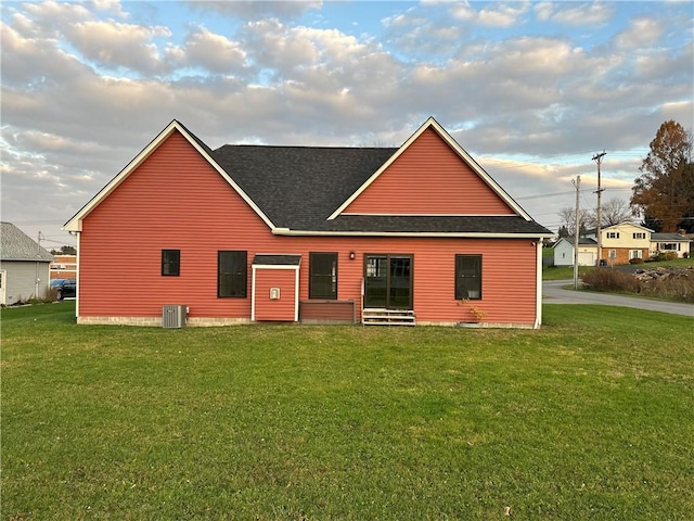 back of property featuring a lawn and cooling unit