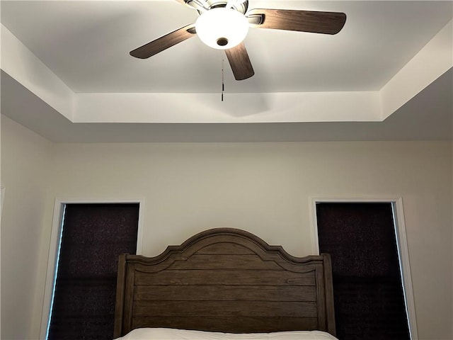 bedroom featuring a tray ceiling and ceiling fan