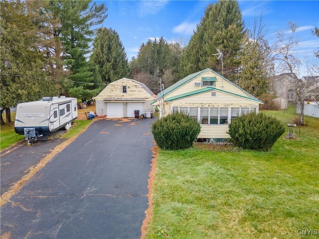 view of front of home featuring an outbuilding, a garage, and a front yard