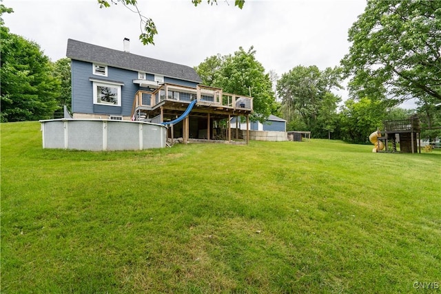 rear view of property featuring a lawn and a playground